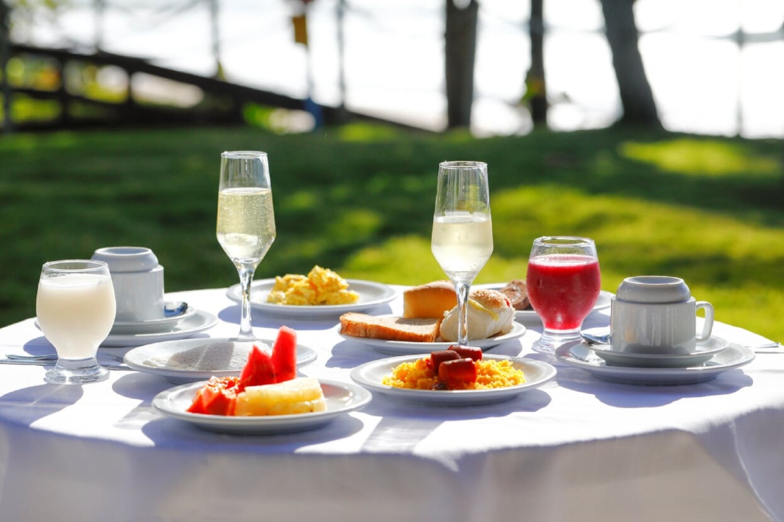Café da manhã servido no jardim com vista para o mar